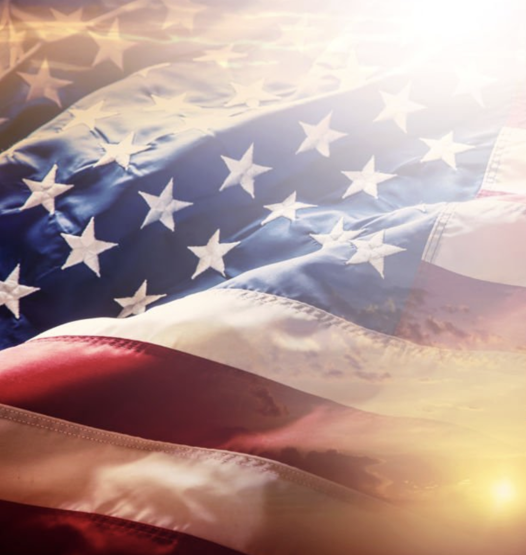 American flag waving against a sunrise sky, symbolizing civic engagement and voting in local elections